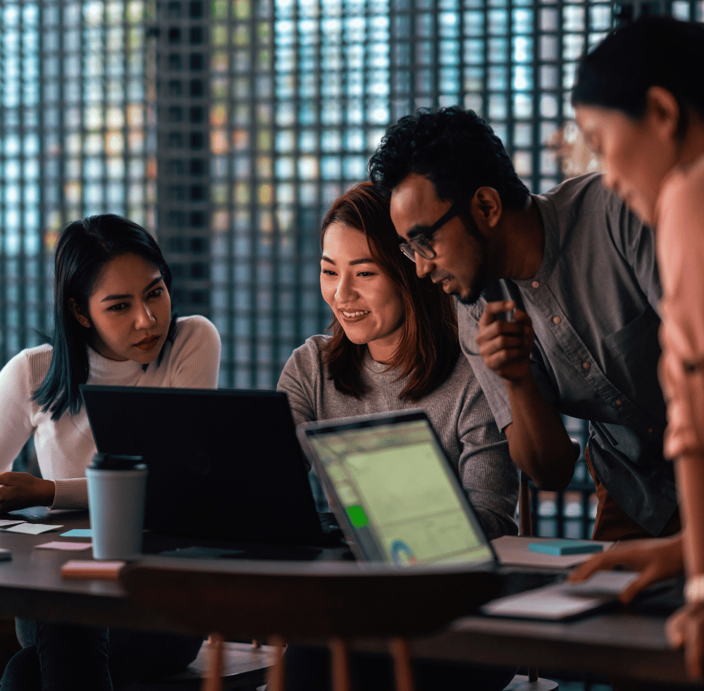 Coworkers crowded around computer 