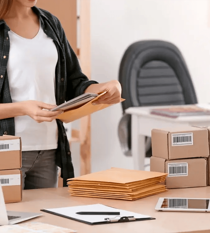 Woman inserting envelopes into packages